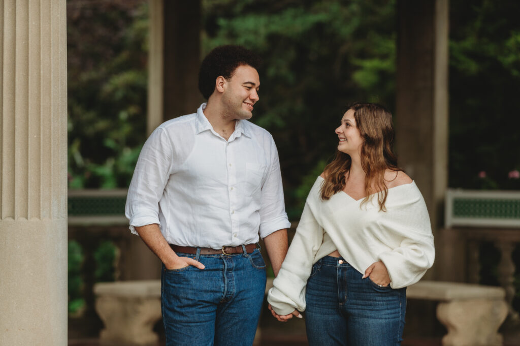 a man and woman look loving at each other with smiles and holding hands