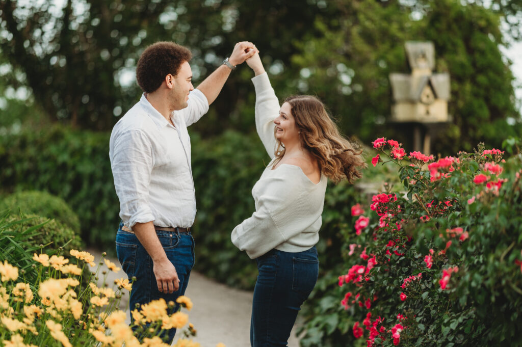 A man twirls a woman amidst the flower gardens at Harkness Memorial State Park