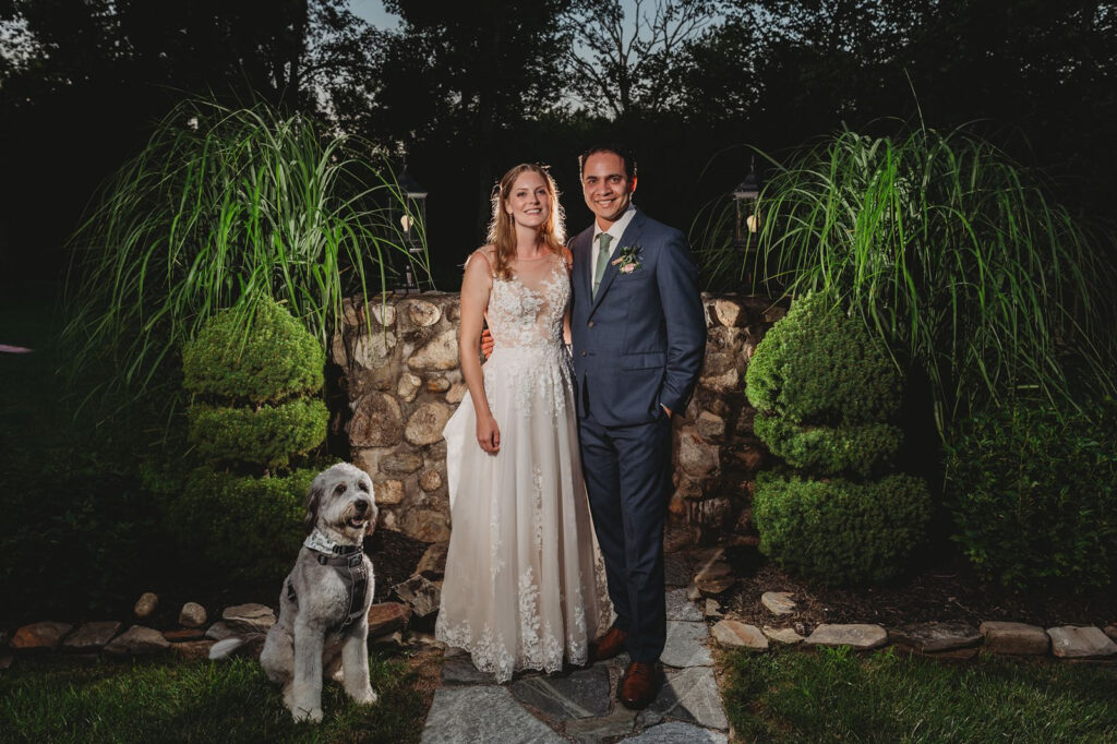 Dog with a couple during night portraits at a wedding, creating a memorable moment