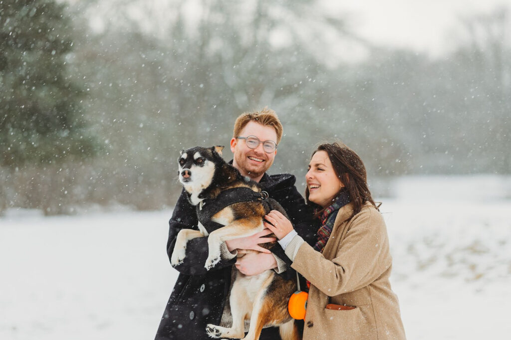 Couple sharing a joyful moment with their pet during engagement photos