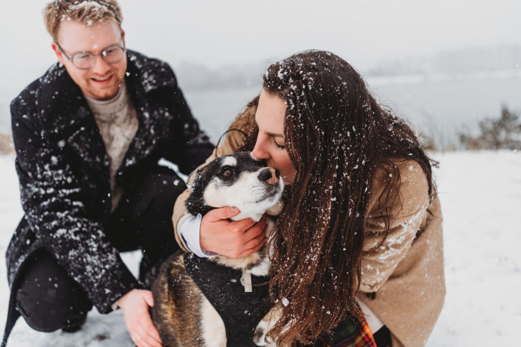 the bride gives her dog a kiss during engagement photos