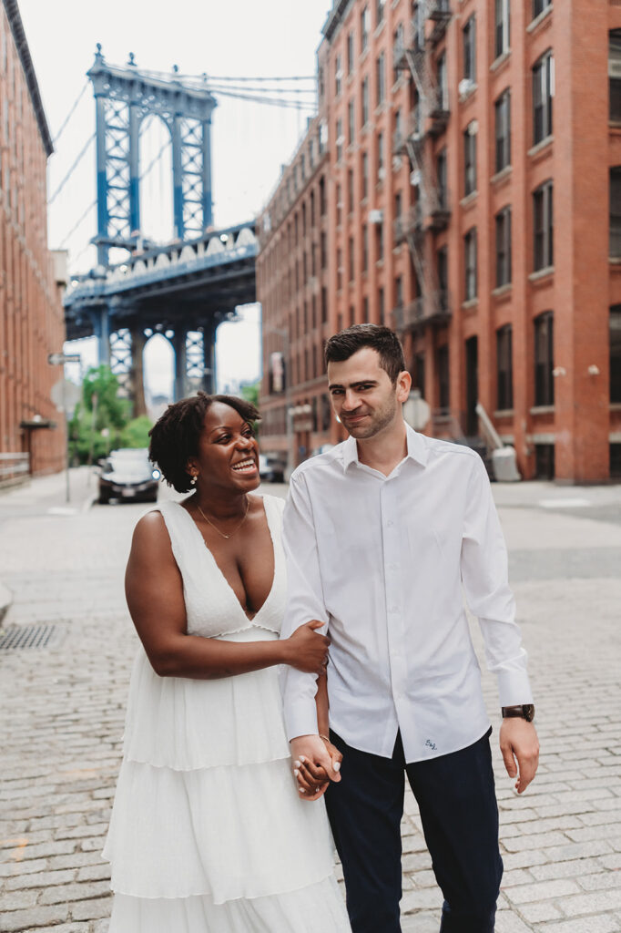 man and woman walking arm in arm in brooklyn for photos with their connecticut engagement photographer