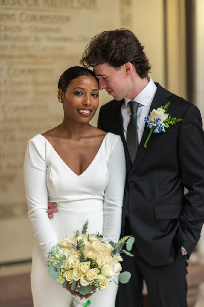 Groom leaning into bride before wedding at Hartford City Hall