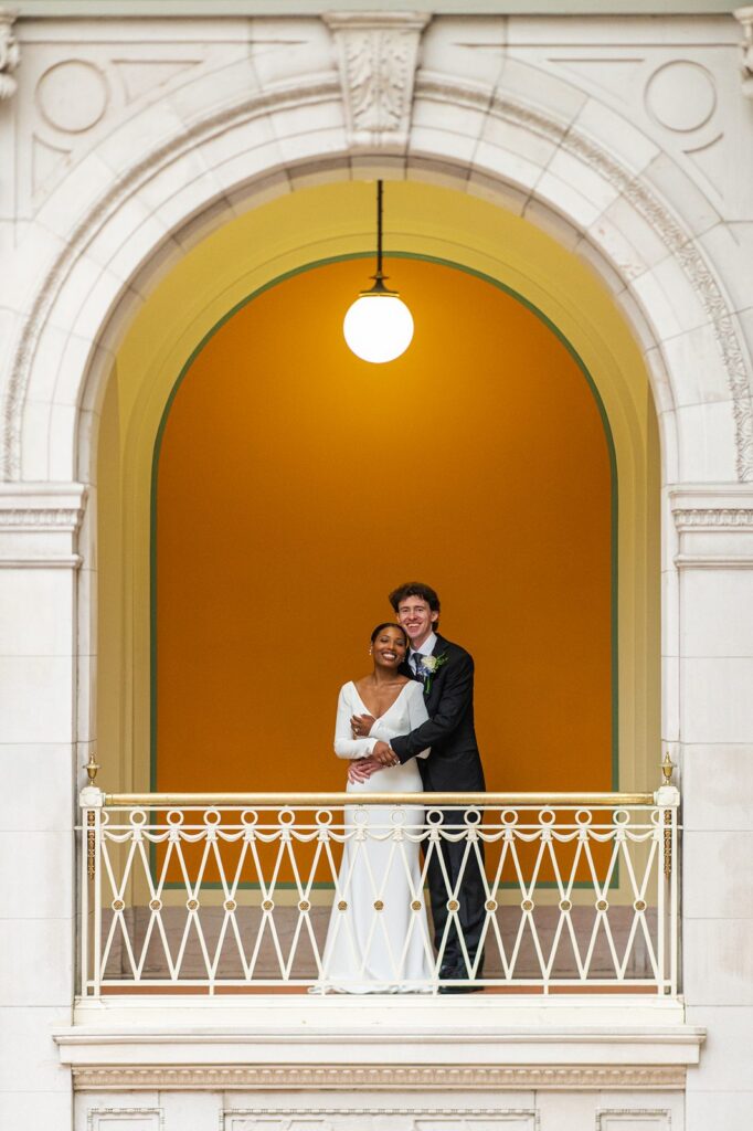 bride and groom embracing in front of the iconic orange wall at hartford city hall