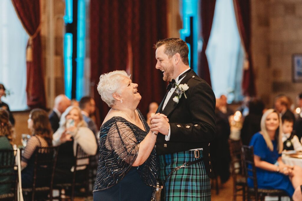groom wearing kilt dances with mom during wedding reception