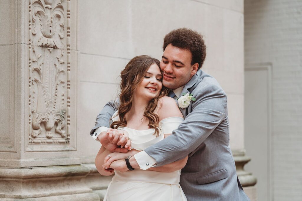 groom embraces bride from behind