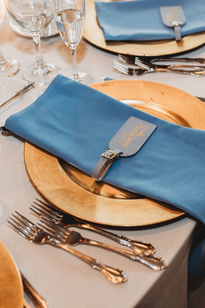 blue napkins atop gold chargers at indoor wedding in Hartford, CT