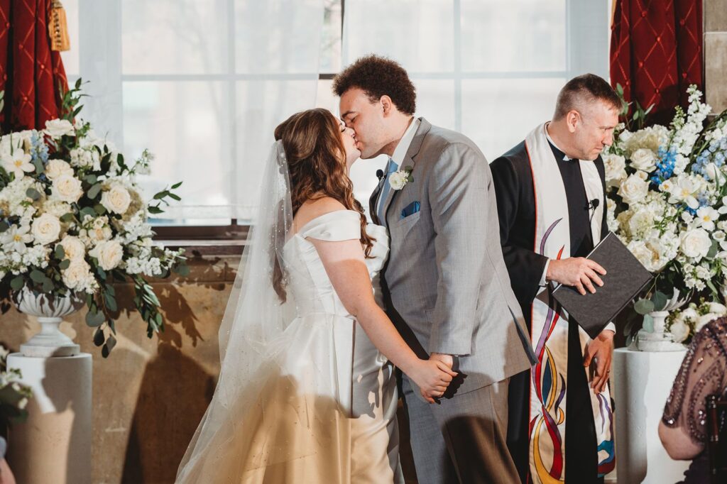 bride and groom kiss during wedding ceremony