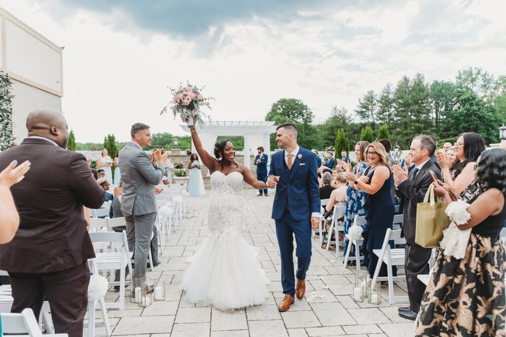 bride and groom celebrating and looking at each other while walking down the aisle at the end of the ceremony.
