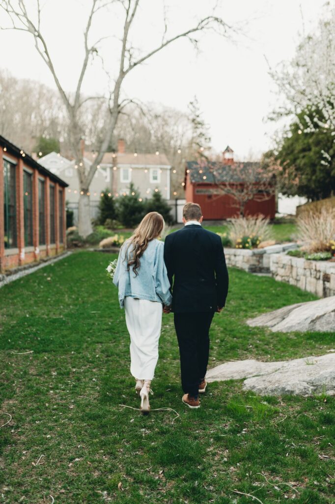 bride and groom walking down the green lawn at the lace factory