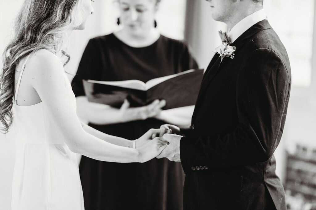 couple holding hands in front of the officiant