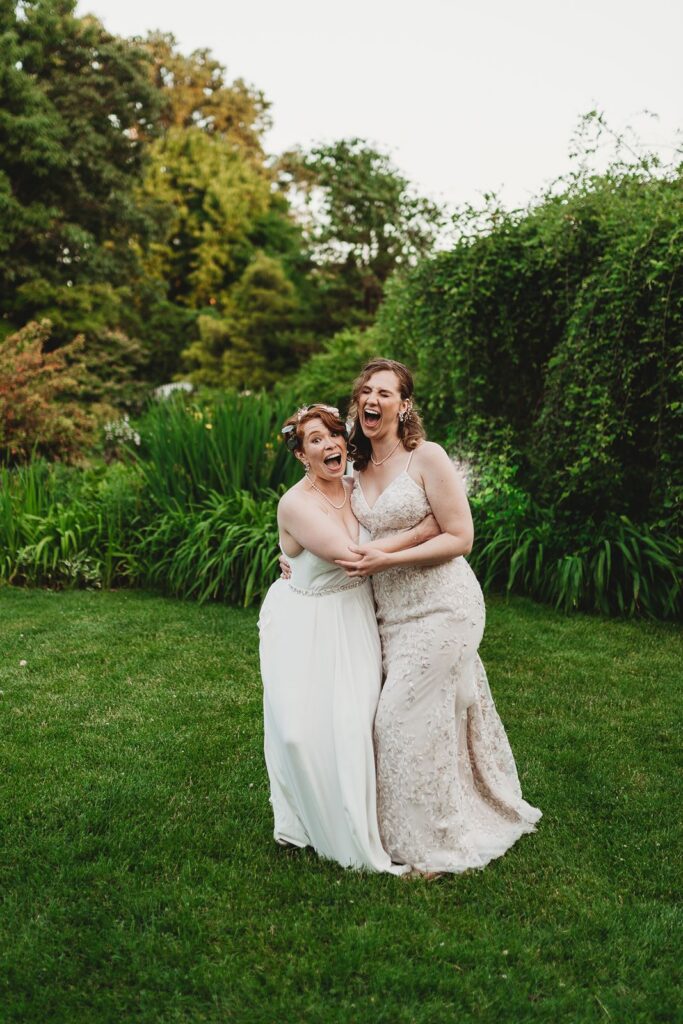 couple giggling and laughing holding each other in the garden of the queens botanical garden