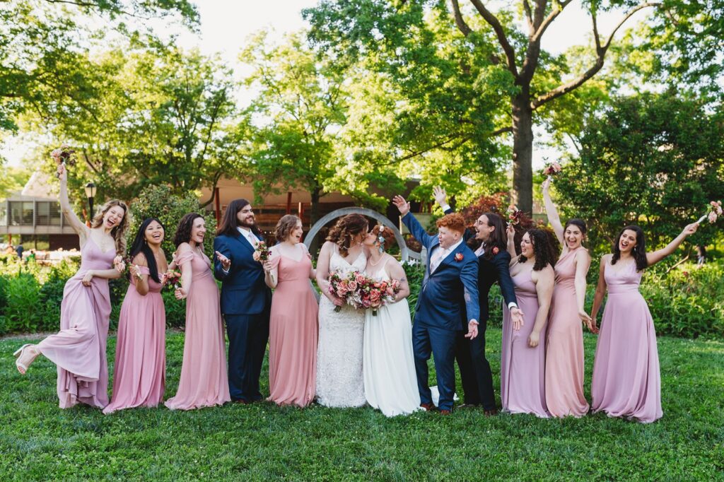 Brides with their wedding party with a beautiful foliage backdrop