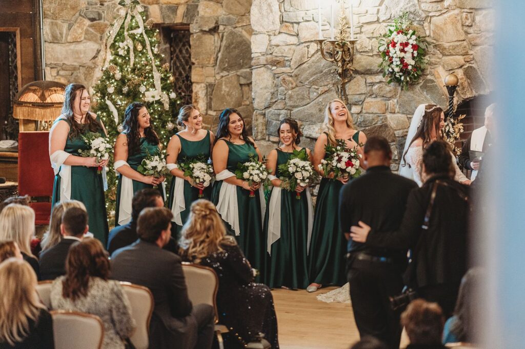 Bridesmaids in dark green dresses in front of the Bill Miller's Castle iconic full height fireplace